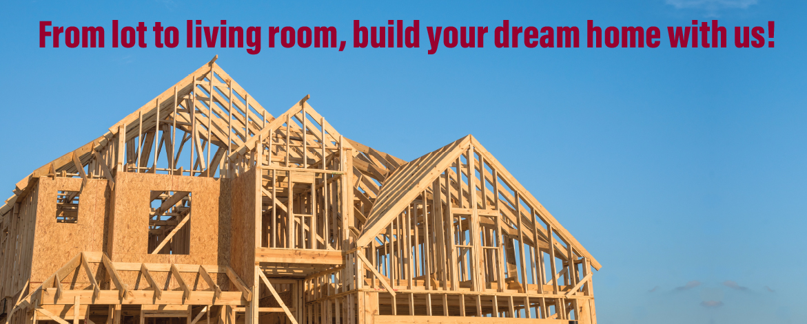 Partially built wooden frame of a house under construction with a blue sky.